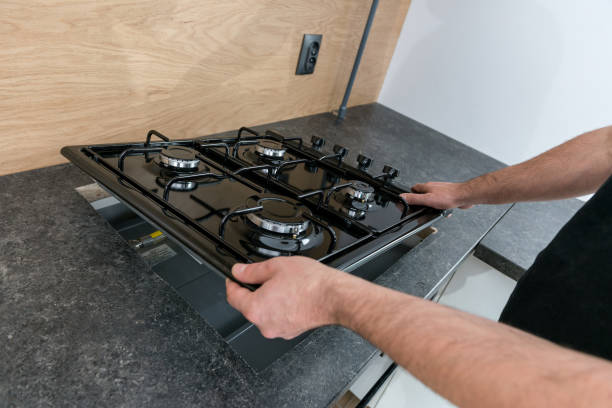 Man installing a gas hob in a kitchen